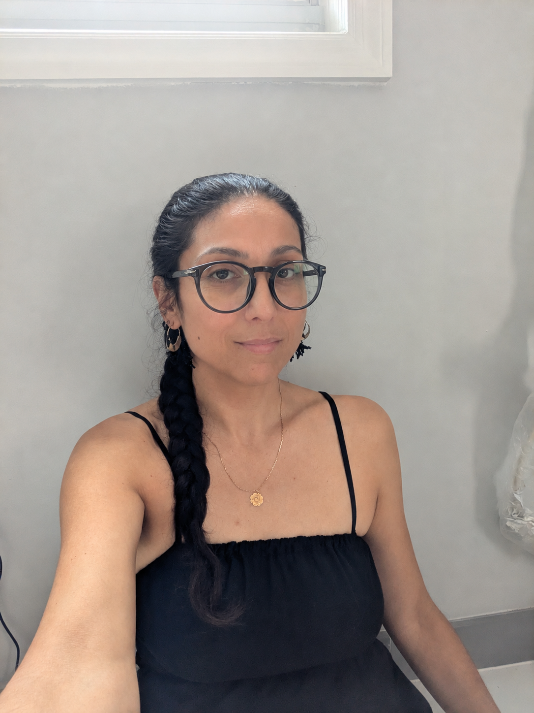 Sandra Acevedo wearing glasses, with a long braid over one shoulder